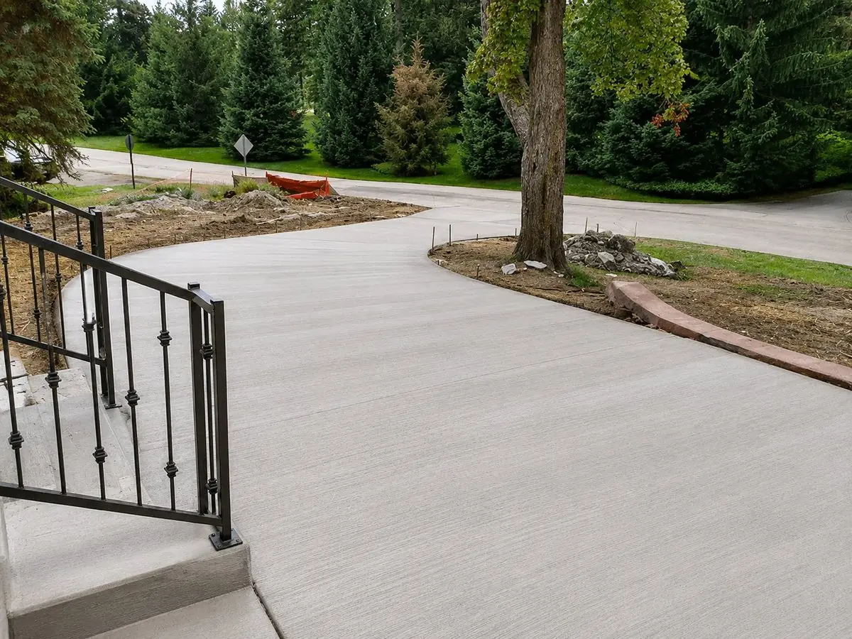 Curved broom-finish concrete driveway with railing
