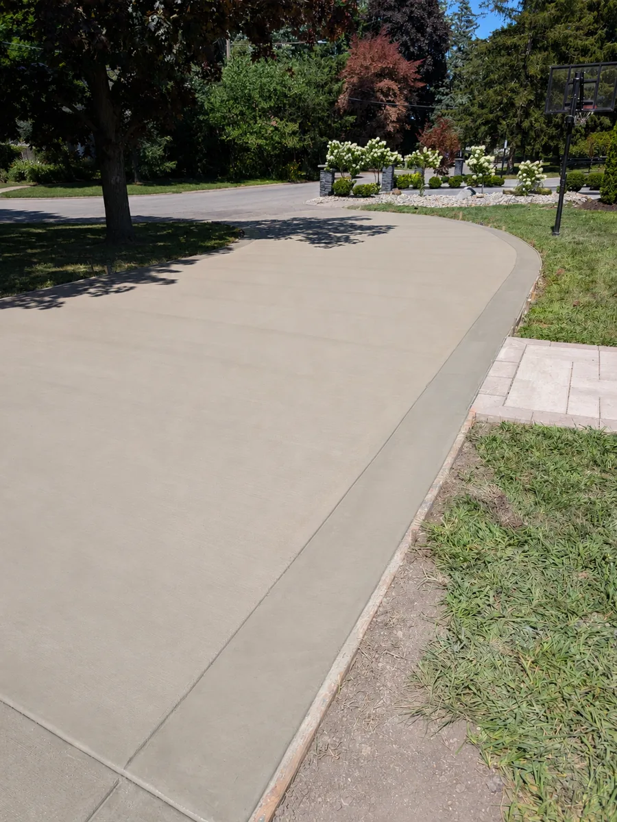 Curved broom-finish concrete driveway with a 12 inch trowel-finished border following the radius, Dearborn Heights MI