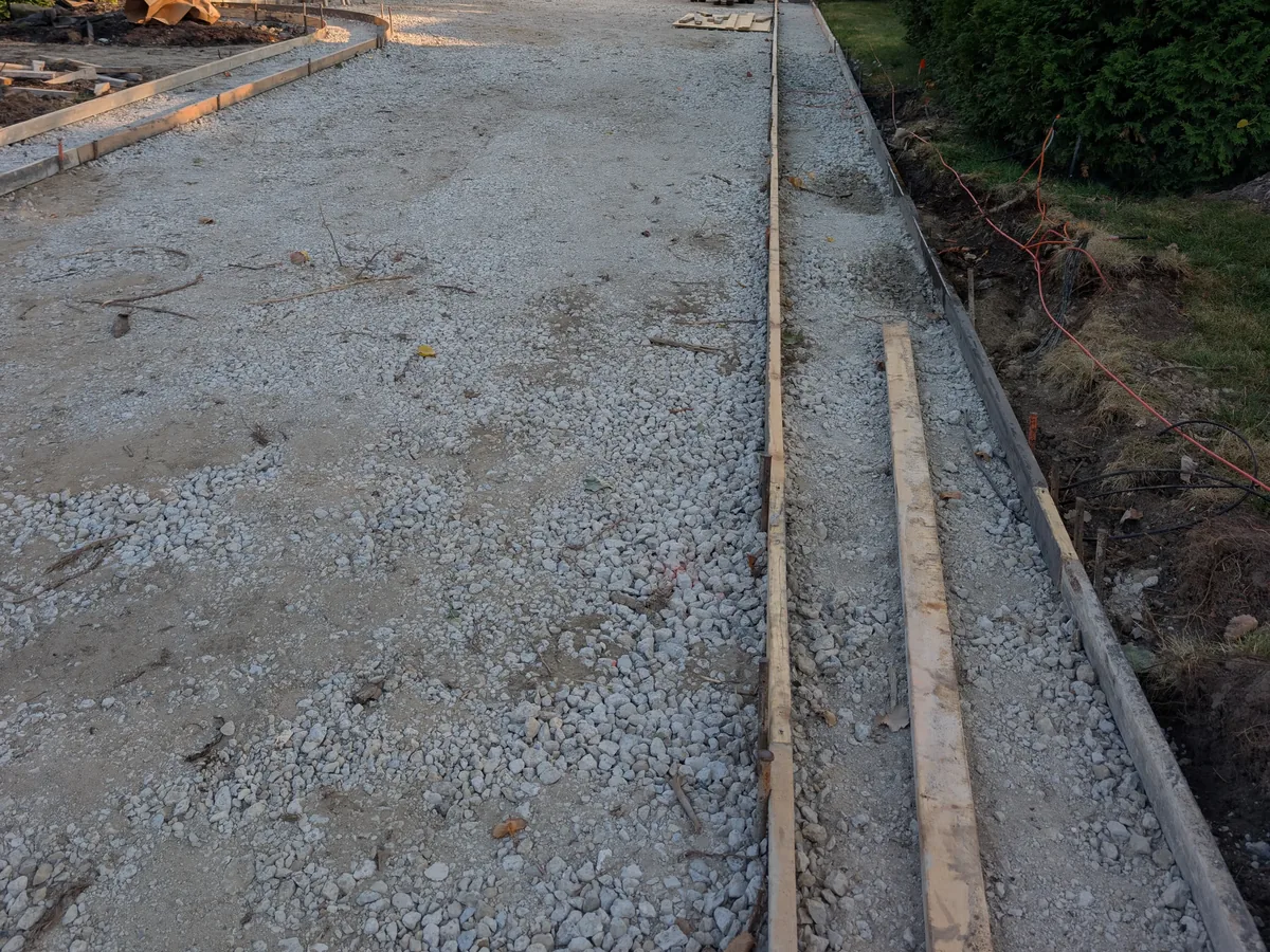 Compacted gravel base and forms set for a new concrete driveway in Troy, MI