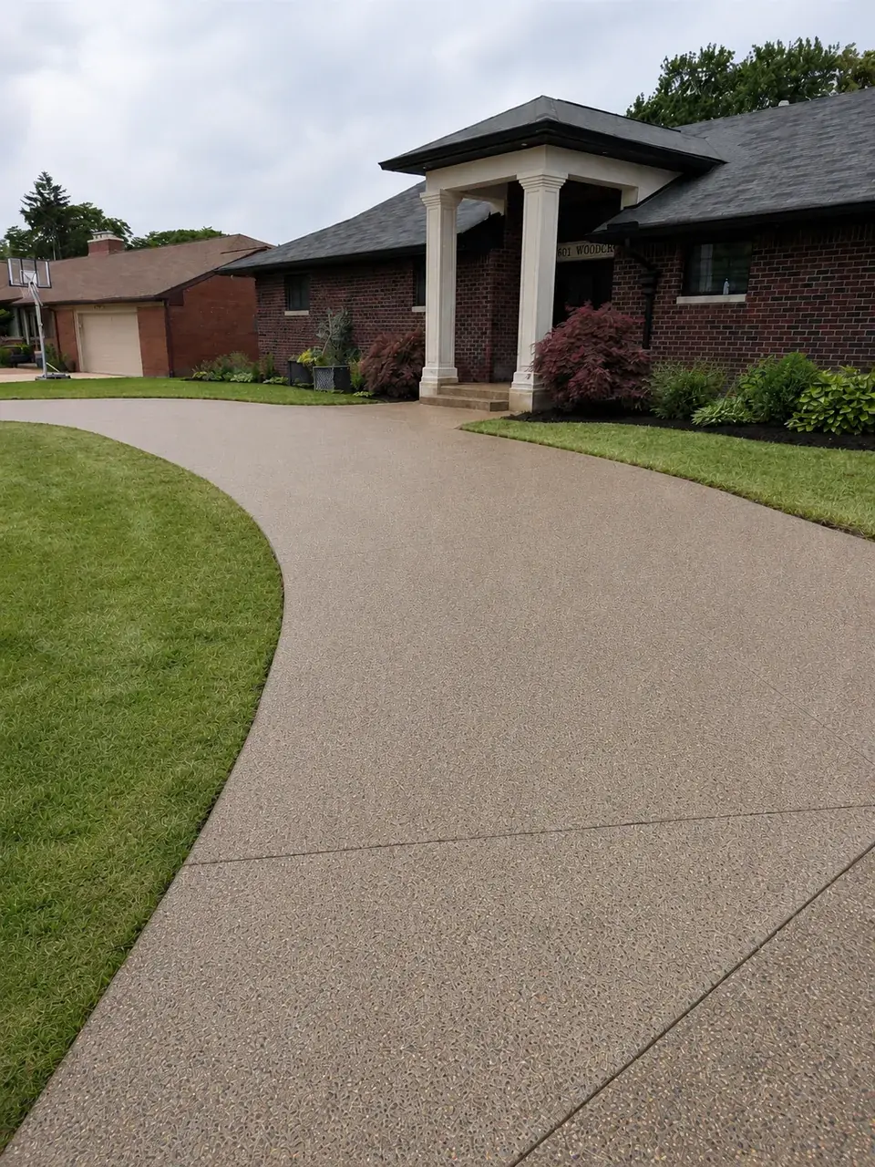 Exposed aggregate curved concrete driveway at a brick home in Dearborn, MI