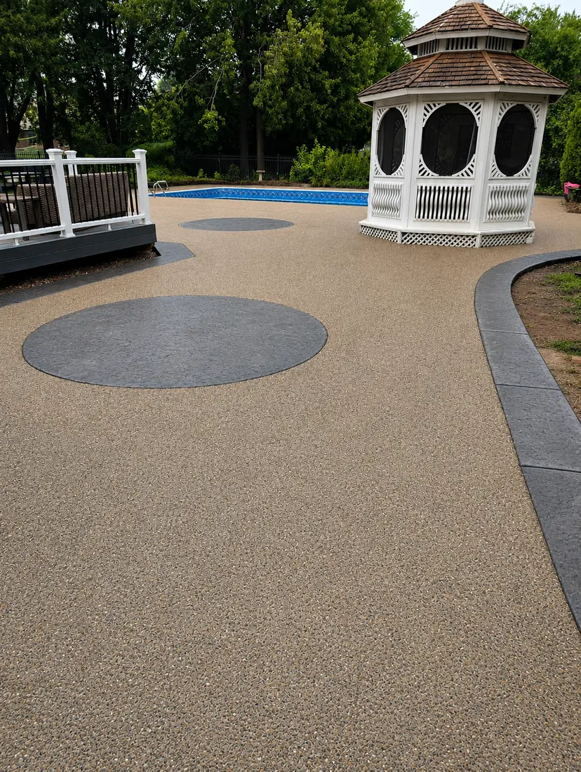Exposed aggregate pool deck with charcoal circle inlays and curved stamped border in Troy, MI